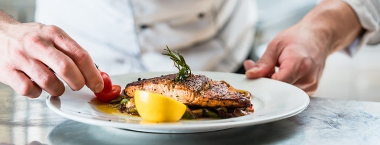  A chef is decorating a dish