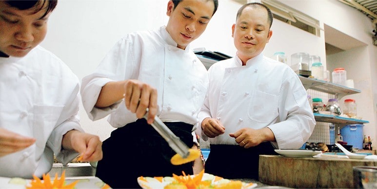 asian chefs working together in kitchen