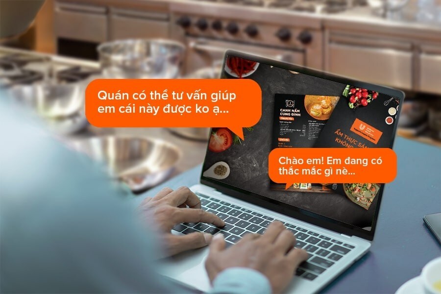 a restaurant staff is responding to his customer’s request on laptop