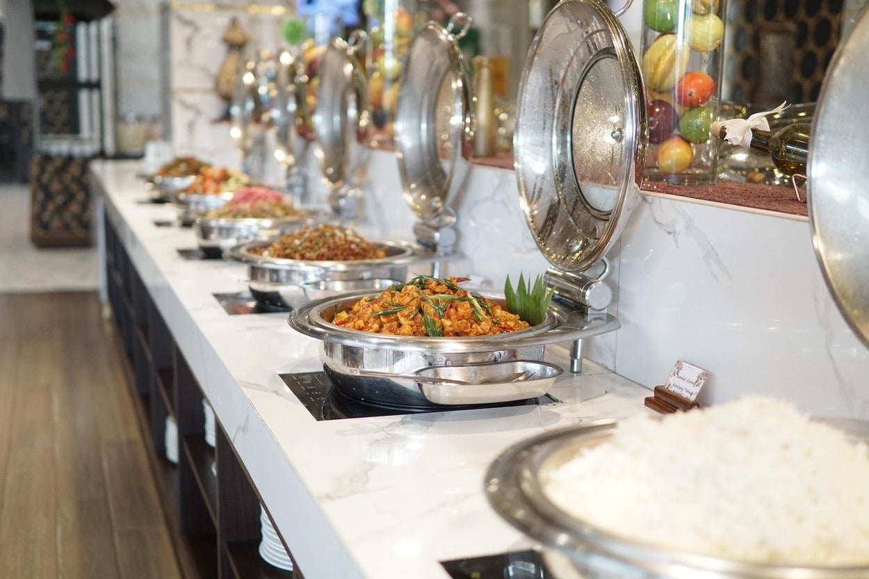 Buffet features a variety of delicious Indonesian and Asian dishes served warm in elegant chafing dishes on a white marble counter
