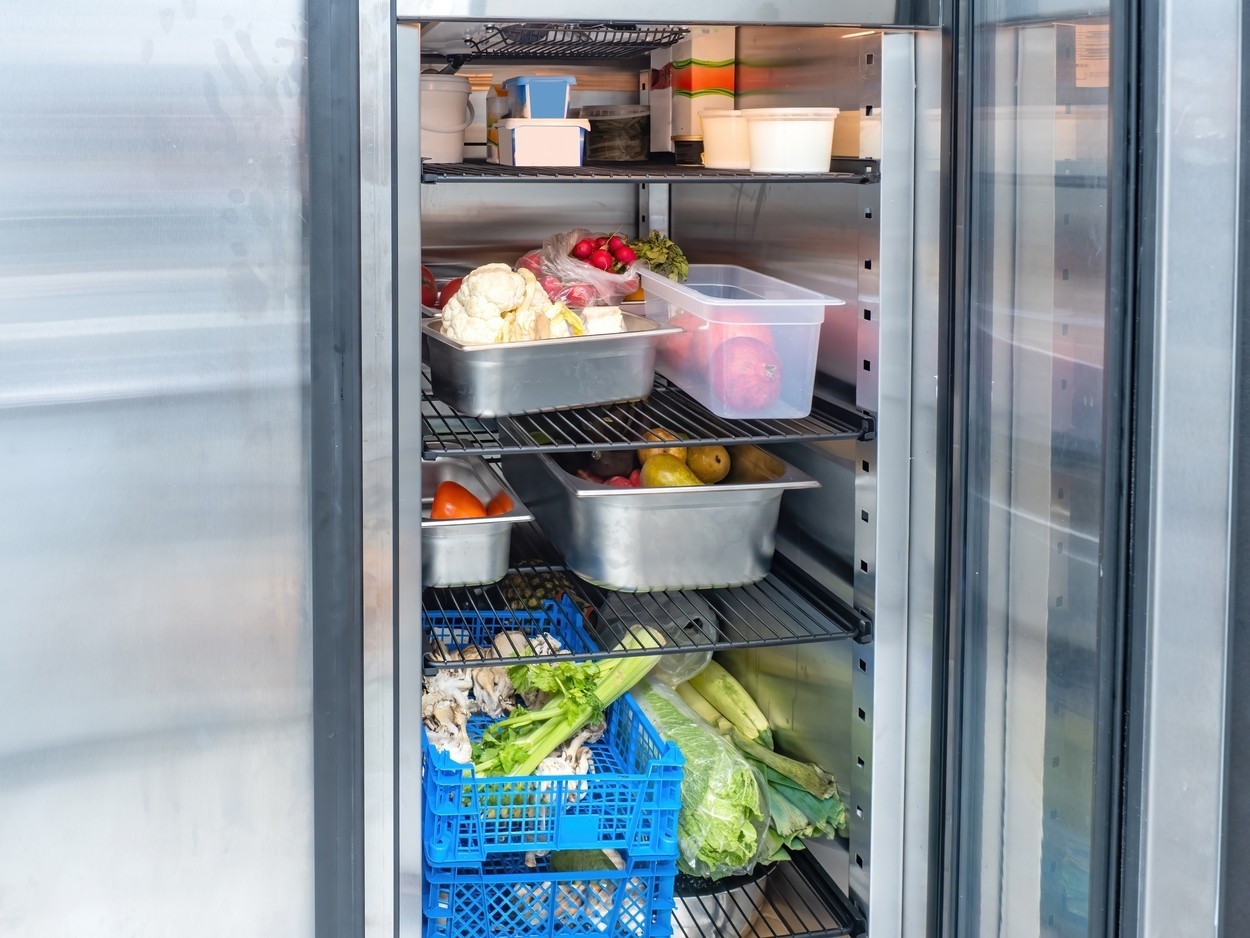 Refrigerator with fresh vegetables. Industrial refrigeration chamber. Steel refrigerator in restaurant kitchen. Equipment for food enterprises. Refrigerator with food. Cold chamber for vegetables