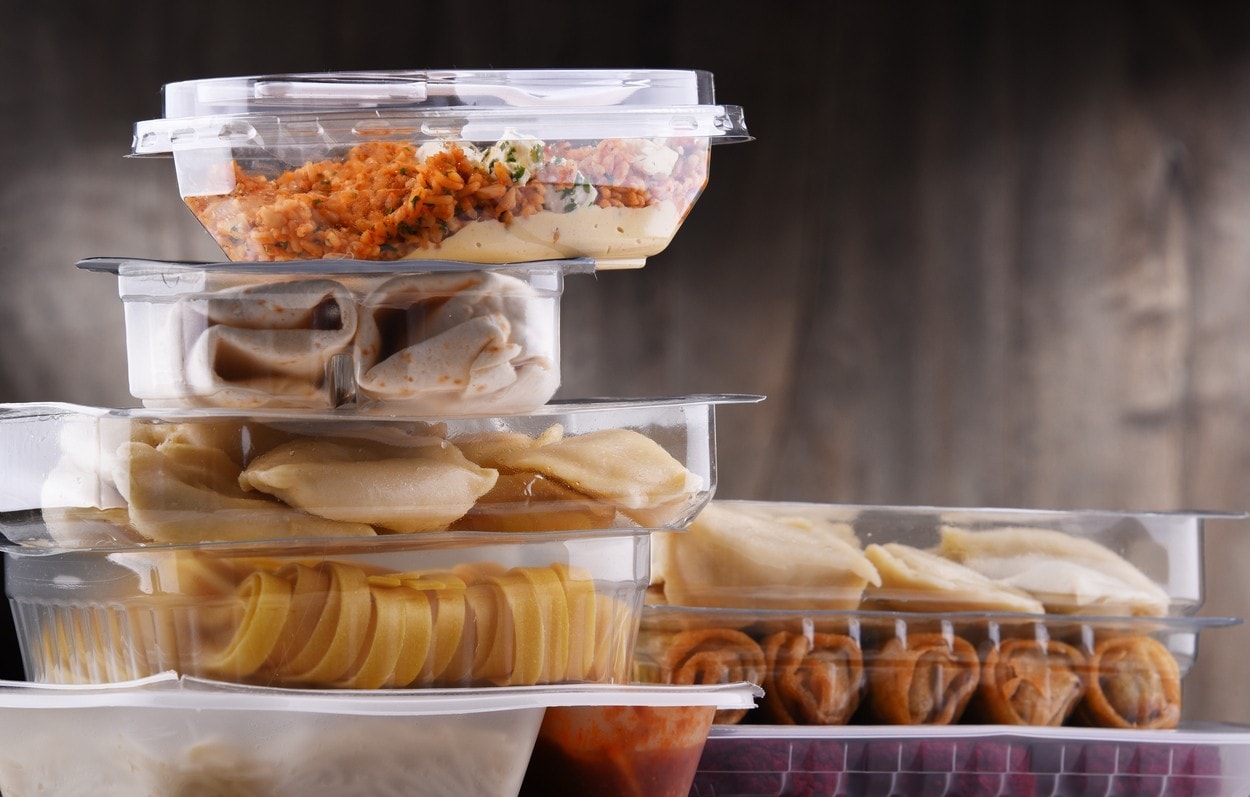 A variety of prepackaged food products in plastic boxes.