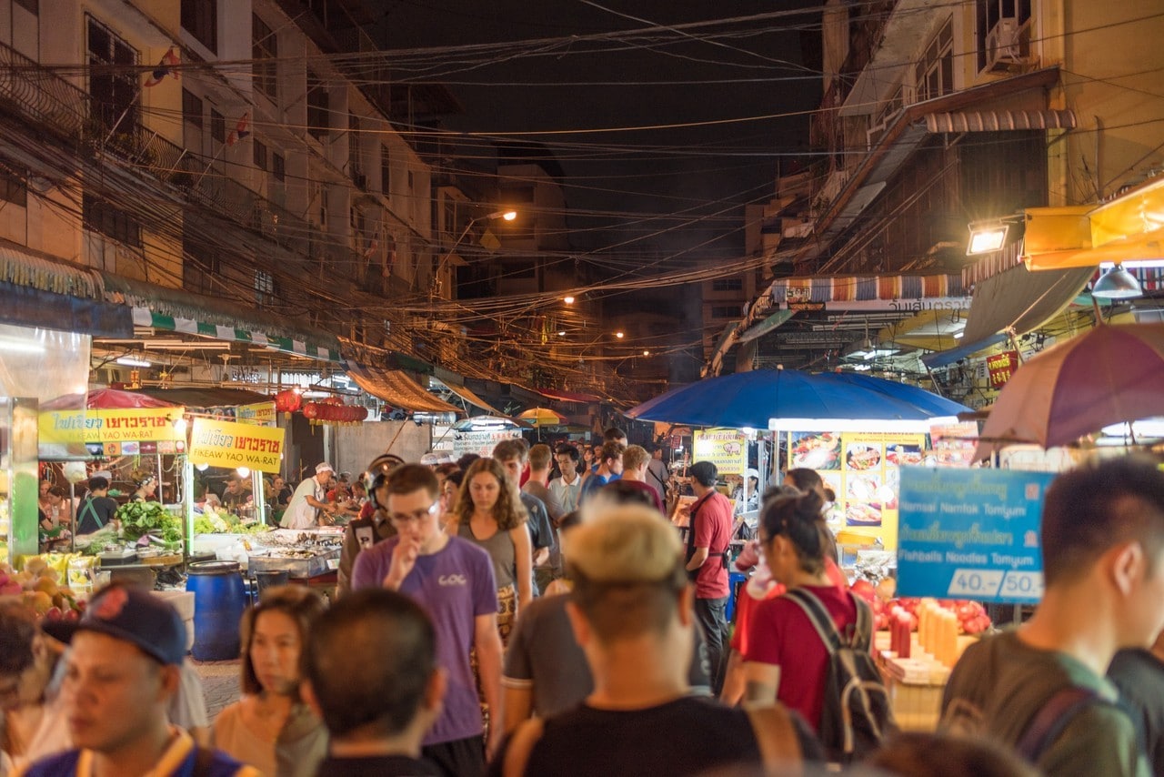 Yaowarat Road passes below lit signs in the Chinatown district at dusk. Yaowarat has been the main center of Chinese culture in Bangkok for over 200 years. Bangkok Thailand China Town and traveller enjoy traviling
