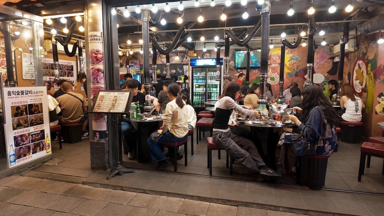 SEOUL, SOUTH KOREA - OCTOBER 11, 2025 - People are dining and socializing at a busy Korean barbecue restaurant in Hongdae, Seoul at night