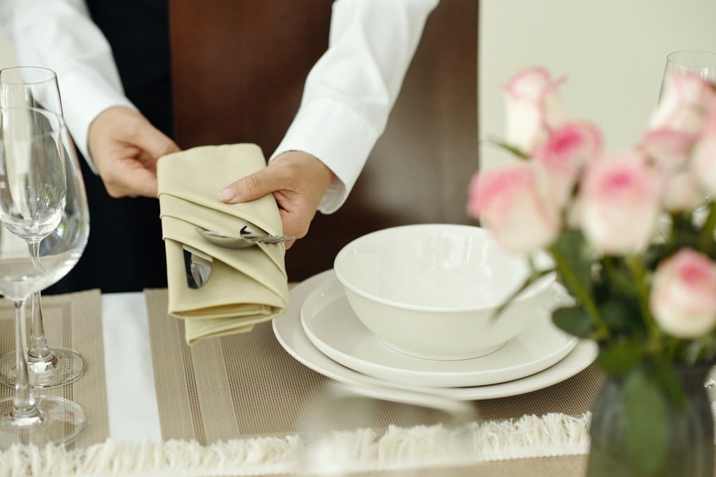 Preparing Elegant Table Setting with Pink Flowers