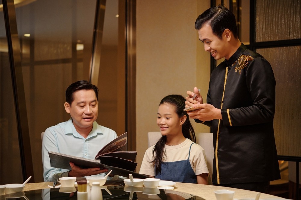 Waiter Talking To Guests In The Restaurants